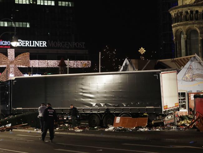 Police officers stand beside a truck which ran into a crowded Christmas market and killed several people in Berlin, Germany on December 19, 2016. Picture: AP