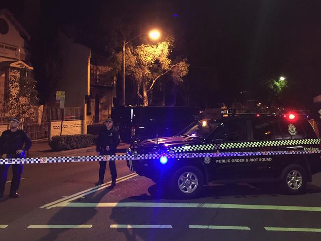NSW Police and forensic officers block the scene at Cleveland Street in Surry Hills.