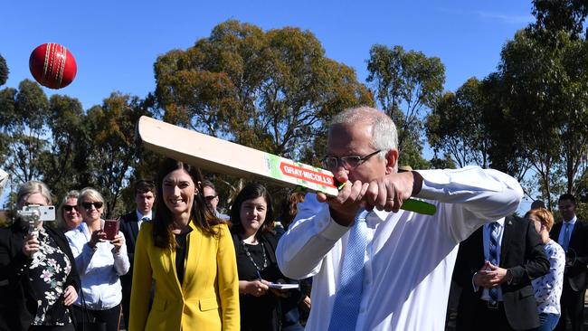 SIX AND OUT? Prime Minister Scott Morrison hits a cricket ball in Boothby as Nicolle Flint looks on. Picture: Mick Tsikas/AAP