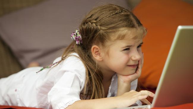 Undated : Injuries from computer use at home ... generic pic - young girl lying down using a laptop computer