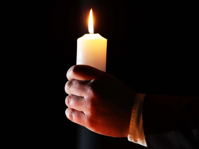 Generic photo of a hand holding a church candle.