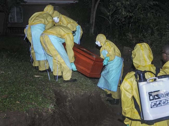 Workers wearing protective clothing bury Agnes Mbambu. Picture: Ronald Kabuubi