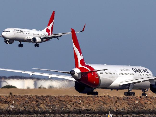 This photo taken on September 4, 2024 shows a Qantas Airways Boeing 737-800 plane coming in to land next to a Qantas Airways Boeing 787 Dreamliner aircraft preparing to take-off at Sydney International Airport. (Photo by DAVID GRAY / AFP)