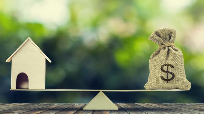 DEPOSIT SAVINGS Money and home,loan,mortgage. Change home into cash concept. US Dollar in sack bag, Wooden house model put on scales on wood table with green tree bokeh as background. Balance home and debt.