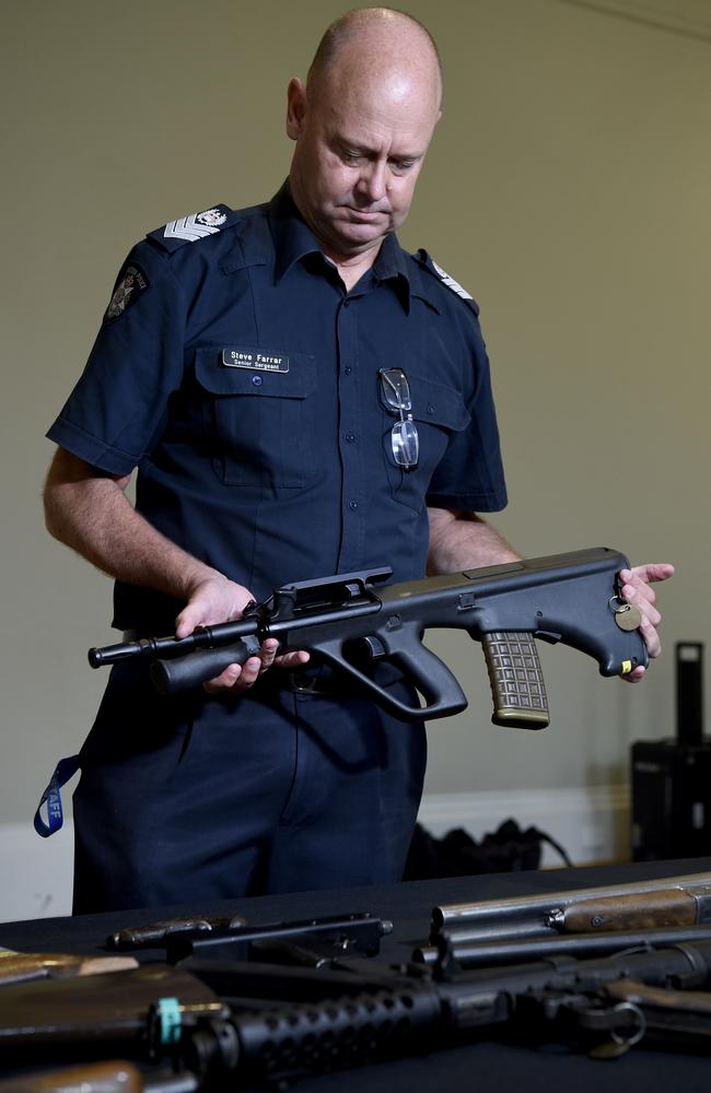 Senior Sergeant Steve Farrar from Victoria Police Ballistics Unit with seized illegal and unregistered firearms. Picture: Andrew Henshaw