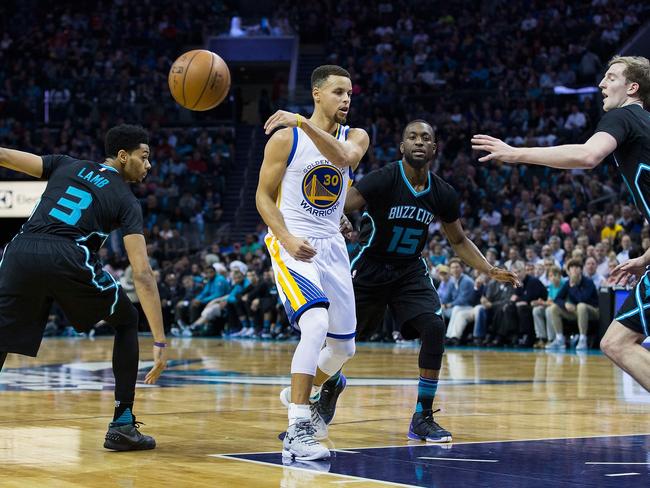 CHARLOTTE, NC - DECEMBER 02: Stephen Curry (30) of the Golden State Warriors makes a no look pass as he is defended by Jeremy Lamb (3), kemba Walker (15) and Cody Zeller (40) of the Charlotte Hornets at Time Warner Cable Arena on December 2, 2015 in Charlotte, North Carolina. The Warriors defeated the Hornets 116-99. Brian A. Westerholt/Getty Images/AFP == FOR NEWSPAPERS, INTERNET, TELCOS & TELEVISION USE ONLY ==