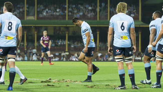 Waratahs players inspect the chewed-up surface. Pic: AAP