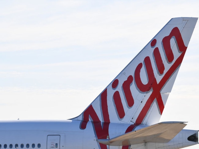 SYDNEY, AUSTRALIA - APRIL 17: The tail of a Virgin Australia Boeing 777 aircraft sits idle at Sydney Airport on April 17, 2020 in Sydney, Australia. The federal government on Thursday announced a $165 million package to assist Qantas and Virgin Australia continue to offer domestic flights to maintain connections with capital cities. Prime Minister Scott Morrison on Thursday flagged that current restrictions in place to stop the spread of COVID-19 could be lifted in four weeks, should Australia's infection rate continue to flatten. Currently, all non-essential business are closed and strict social distancing rules are in place, while public gatherings are limited to two people. New South Wales and Victoria have enacted additional lockdown measures to allow police the power to fine people who breach the two-person outdoor gathering limit or leave their homes without a reasonable excuse. Queensland, Western Australia, South Australia, Tasmania and the Northern Territory have all closed their borders to non-essential travellers and international arrivals into Australia are being sent to mandatory quarantine in hotels for 14 days. (Photo by James D. Morgan/Getty Images)Panel - box outescape november 15 2020 doc holiday