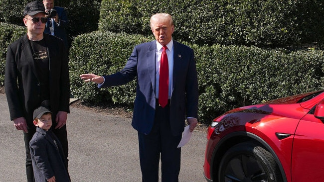 Mr Trump, Mr Musk and one of Mr Musk’s children stand next to a Tesla car outside the White House. Picture: Andrew Harnik/Getty Images