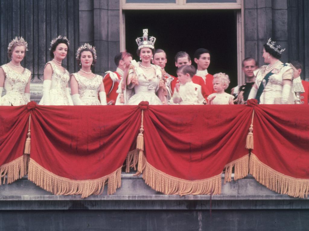 The newly crowned Queen Elizabeth II waves to the crowd from the balcony at Buckingham Palace on June 2, 1953. Her children Prince Charles and Princess Anne stand with her. Picture: Getty