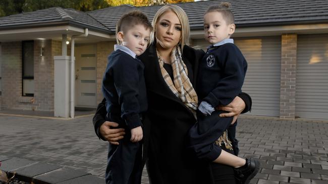 Young mum Amy Savage with her twin sons Cruz and Cash at their current home in Ridgehaven, which they will have to leave. Picture: Naomi Jellicoe