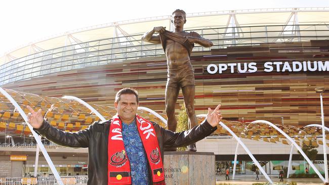 Nicky Winmar with a stature of his iconic pose outside Optus Stadium. Picture: Jackson Flindell