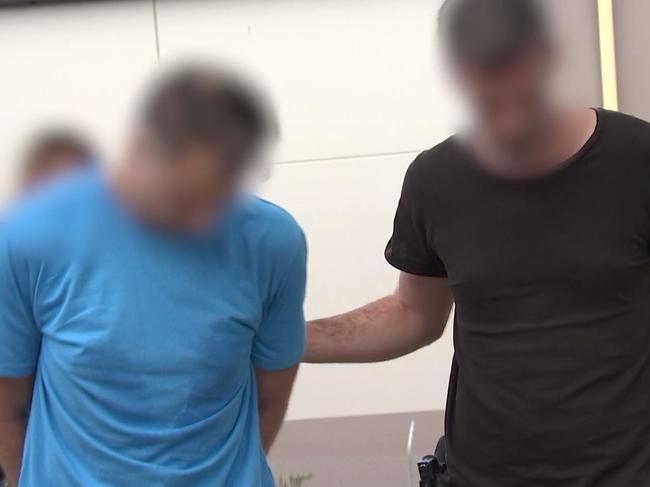 Finlayson (wearing blue) is arrested by police on Tuesday, Picture: NSW Police