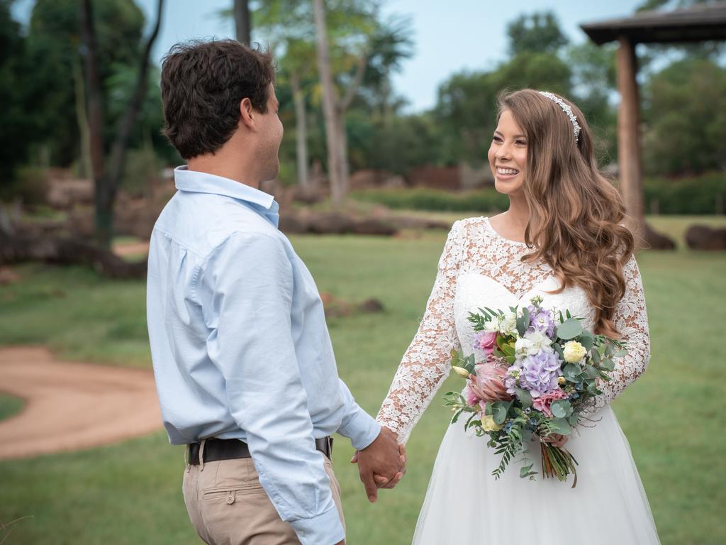 Chandler Powell and Bindi Irwin on their wedding day holding hands and smiling. Picture: Kate Berry