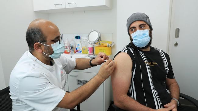 Gregory Lambrousis, 29, receives the AstraZeneca vaccine from pharmacist Nadeem Ahmad at Priceline in Liverpool in southwest Sydney. Picture: John Feder/The Australian.