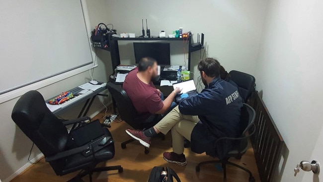 AFP officers search Fan’s computer during a raid on his Blacktown home last July. Picture: AFP