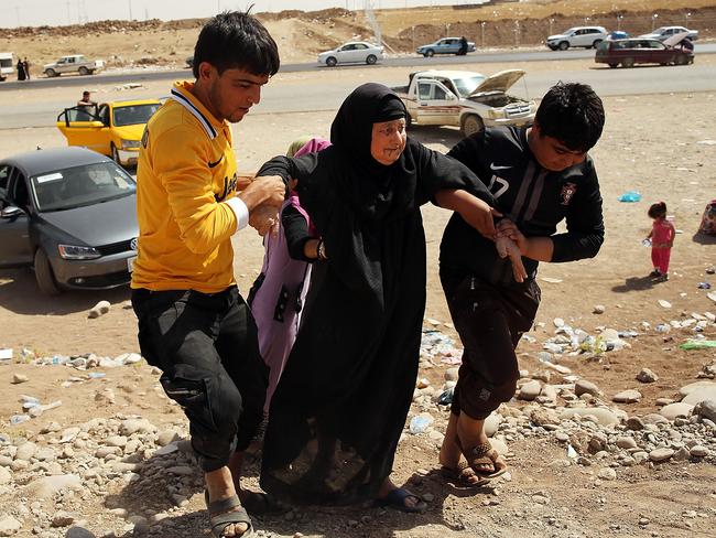 An elderly woman is helped into a temporary displacement camp for Iraqis caught-up in the fighting in and around the city of Mosul, Iraq. Picture: Spencer Platt/Getty Images