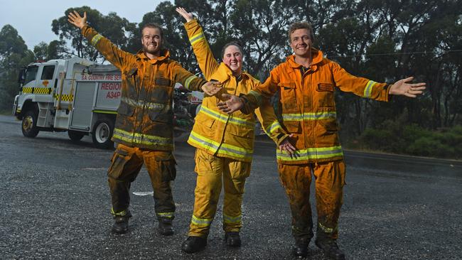 CFS volunteers Nick Svetec from Barmera, Hayllee Camplbell from Morgan and Joel Trace from Barmera celebrate the rain falling on the Cherry Gardens fire. Picture: Tom Huntley