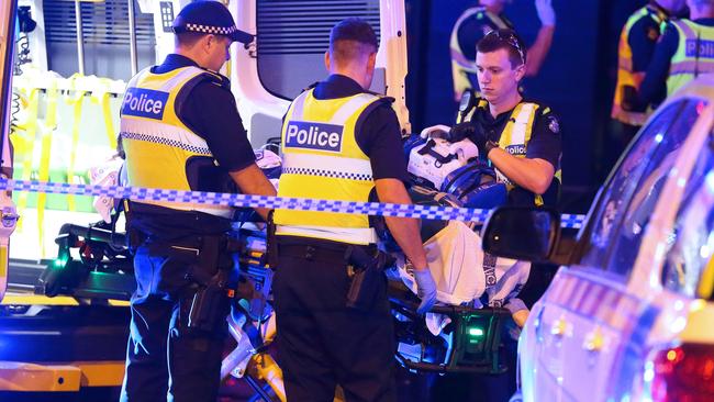 Police stand close as the man is placed in the back of an ambulance. Picture: Patrick Herve