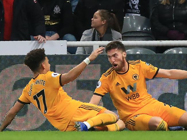 Wolverhampton Wanderers' Irish defender Matt Doherty (R) celebrates with Wolverhampton Wanderers' English midfielder Morgan Gibbs-White (L) after scoring their late winner during the English Premier League football match between Newcastle United and Wolverhampton Wanderers at St James' Park in Newcastle-upon-Tyne, north east England on December 9, 2018. - Wolves won the game 2-1. (Photo by Lindsey PARNABY / AFP) / RESTRICTED TO EDITORIAL USE. No use with unauthorized audio, video, data, fixture lists, club/league logos or 'live' services. Online in-match use limited to 120 images. An additional 40 images may be used in extra time. No video emulation. Social media in-match use limited to 120 images. An additional 40 images may be used in extra time. No use in betting publications, games or single club/league/player publications. /