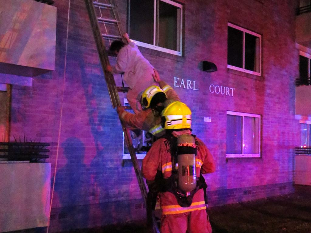 Firefighters rescue one of the occupants of the Villawood unit block.