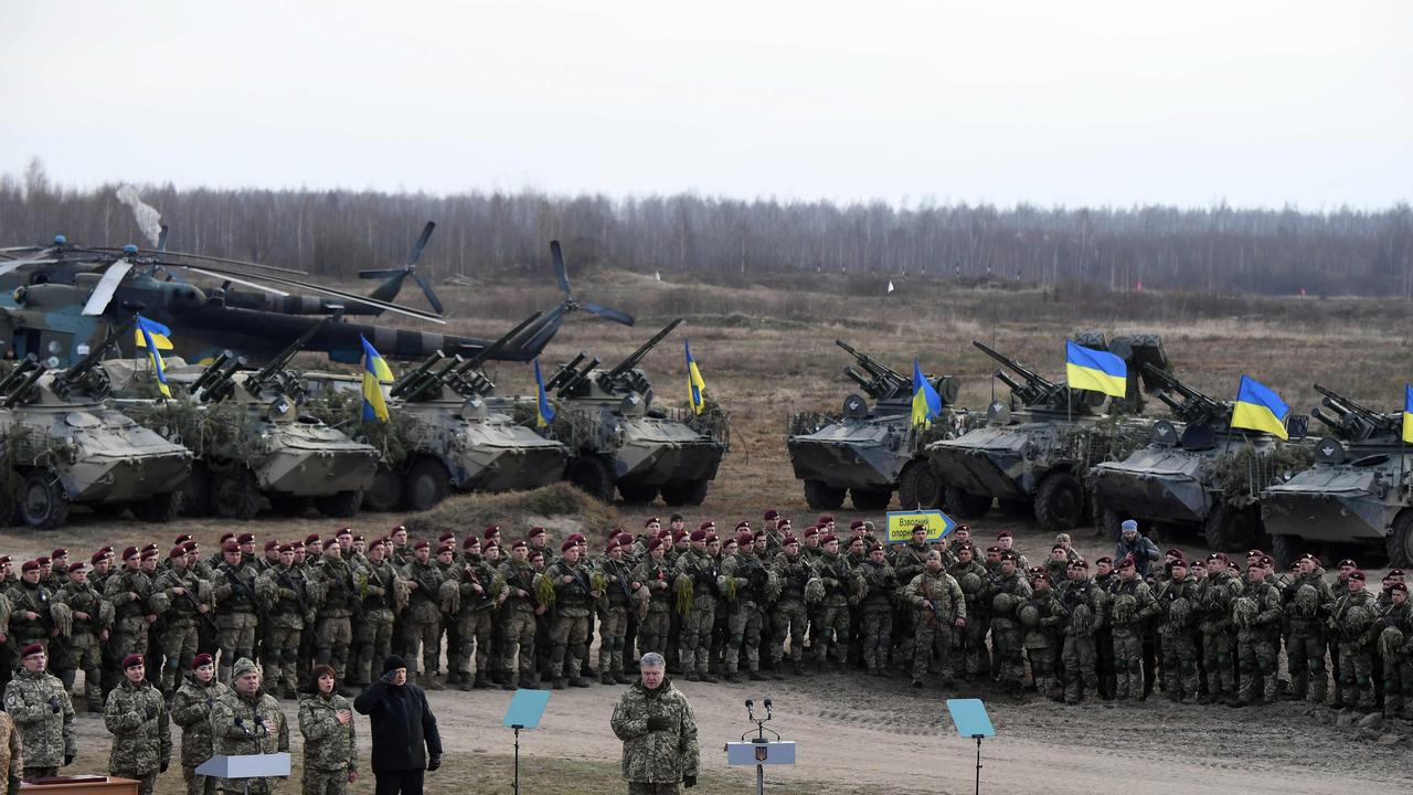 Ukrainian President Petro Poroshenko stands with Ukrainian servicemen of the airborne troops as they sing the Ukrainian national anthem. Picture: AFP