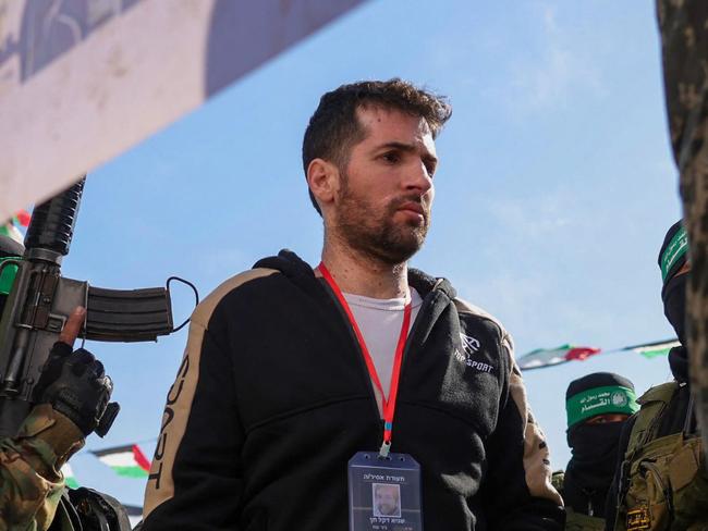 TOPSHOT - Hamas militants escort Israeli-American hotsage Sagui Dekel-Chen on a stage before handing him over to a Red Cross team in Khan Yunis, southern Gaza Strip, on February 15, 2025, as part of the sixth hostage-prisoner exchange. (Photo by Bashar TALEB / AFP)