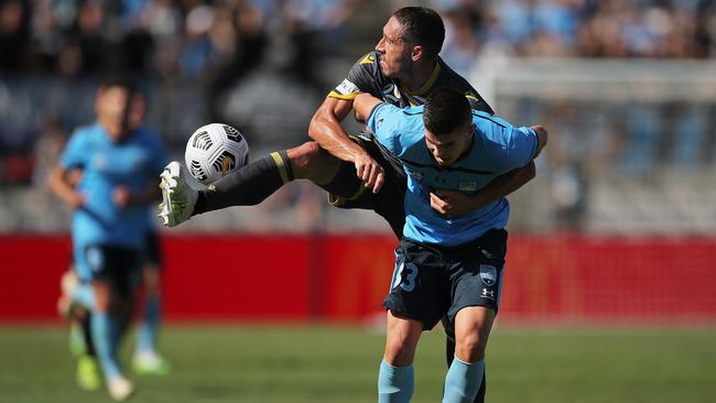 Bulls player Mark Milligan competes for the ball against Patrick Wood of Sydney FC.