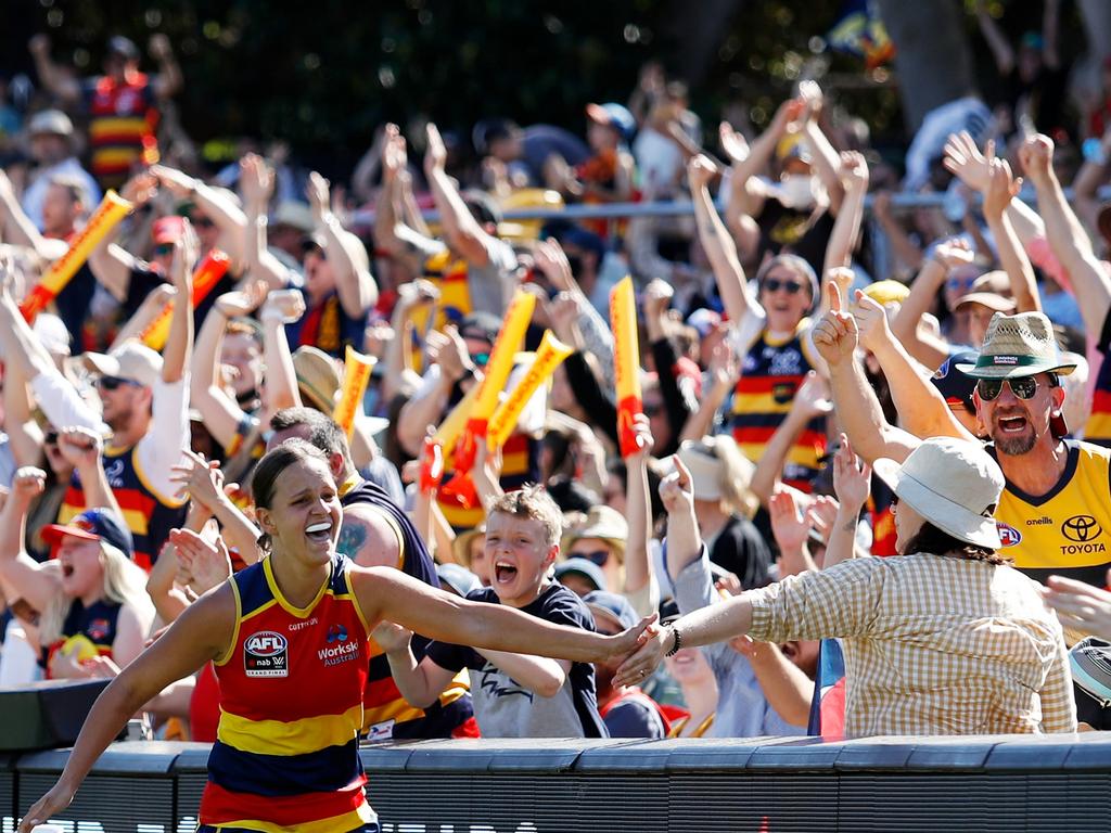 Ponter celebrates with an Adelaide Crows fan. Picture: Dylan Burns/AFL Photos via Getty Images.