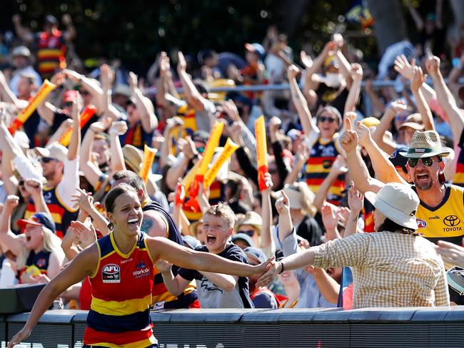 Ponter celebrates with an Adelaide Crows fan. Picture: Dylan Burns/AFL Photos via Getty Images.