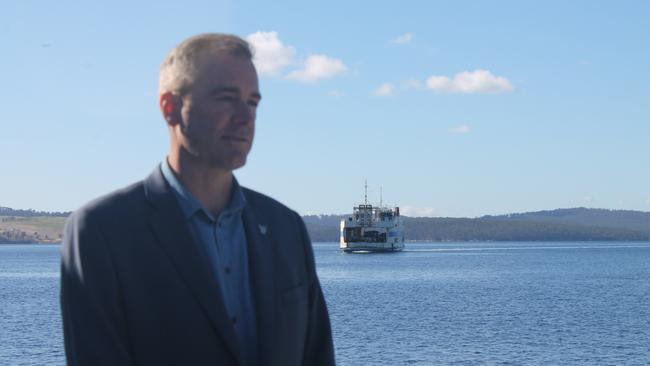 Transport Minister Michael Ferguson discusses the new Bruny Island ferry Parrabah as the Mirambeena ferry looms behind him. Picture: ANNIE MCCANN