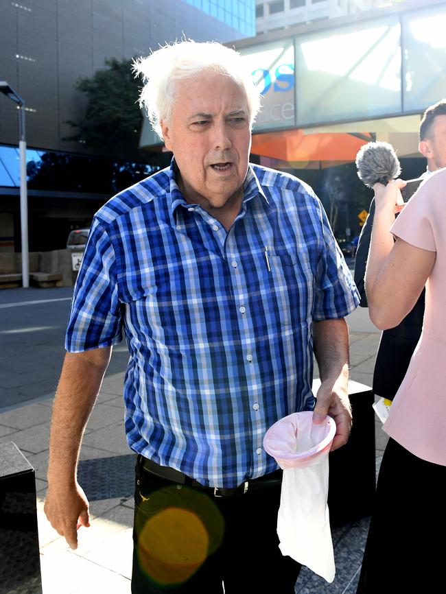 Clive Palmer arrives at the Federal Court in Brisbane holding a sick bag in May 2017. Picture: AAP Image/Dave Hunt