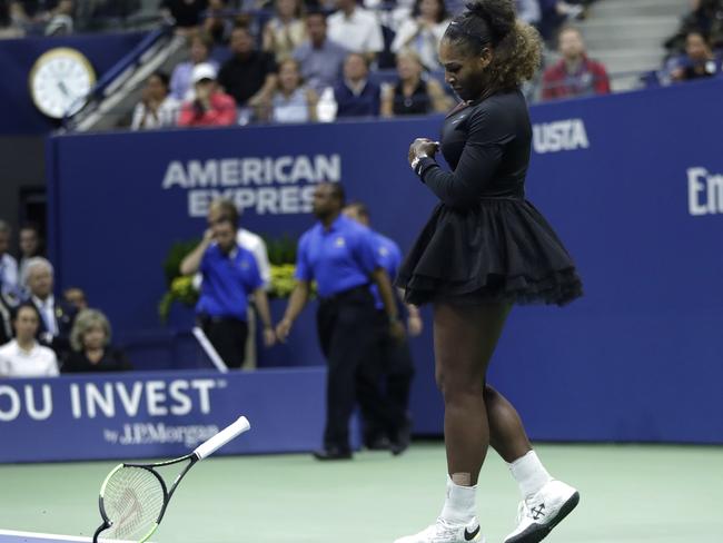 An angry Serena Williams smashes her racquet. Picture: AP