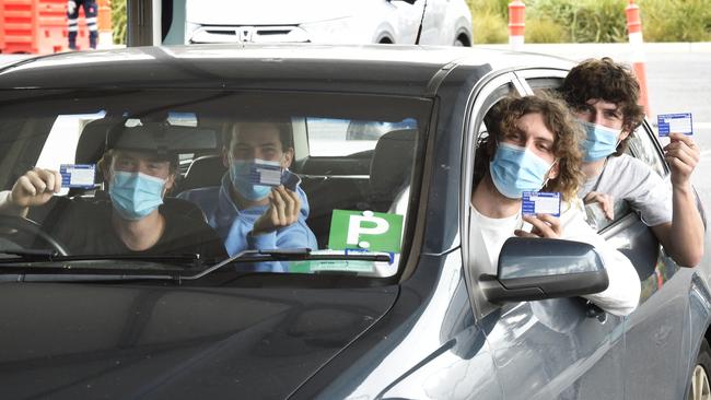 A car of young men show proof of their first vaccination. Picture: Andrew Henshaw