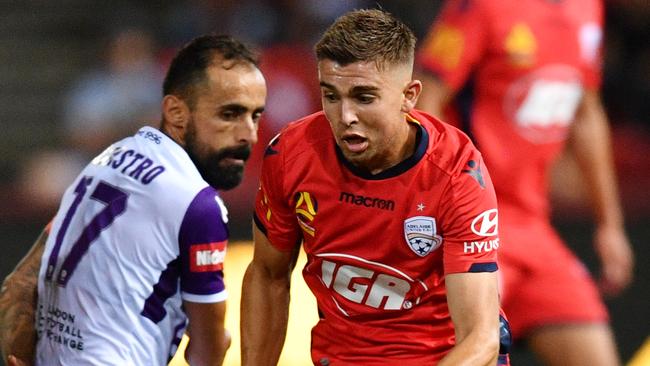 Adelaide United’s Nathan Konstandopoulos gets past Perth Glory’s Diego Castro on Friday night. Picture: AAP 