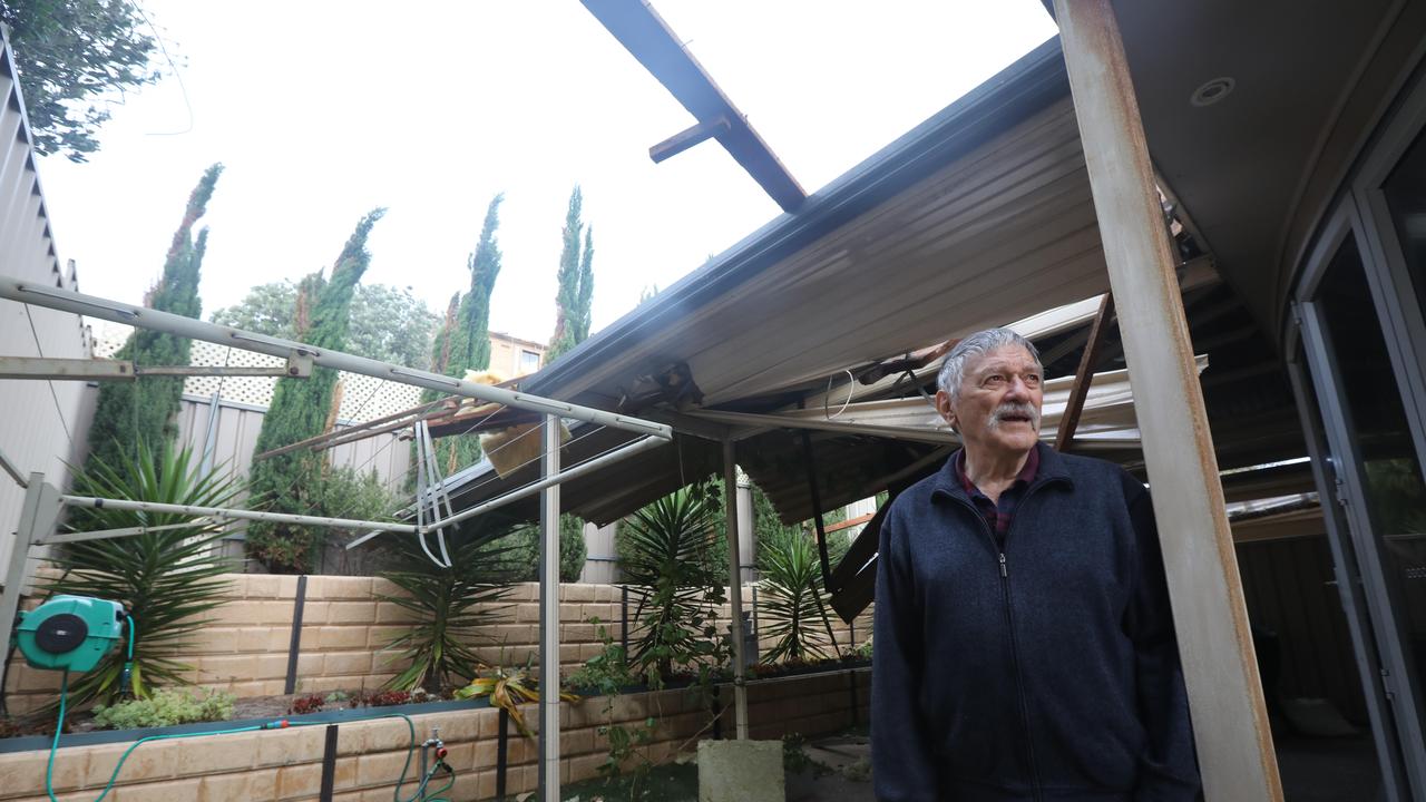 Glenelg North resident Brenton Nayda in his backyard, where the roof off the neighbouring apartment building ended up. Picture: AAP / Russell Millard