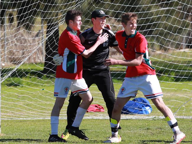 Ryan Stieglbauer and Joel Every congratulate goalkeeper Ryan Hancock after he kicked a field length goal for his the students.