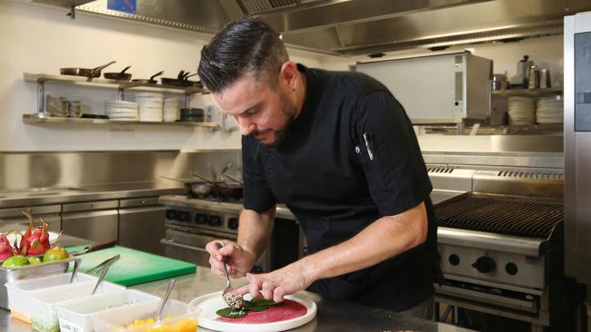 Executive chef at Silky Oaks Lodge Mark Godbeer prepares a prawn dish with locally grown betel leaf, chilli and mango. Picture: Brendan Radke