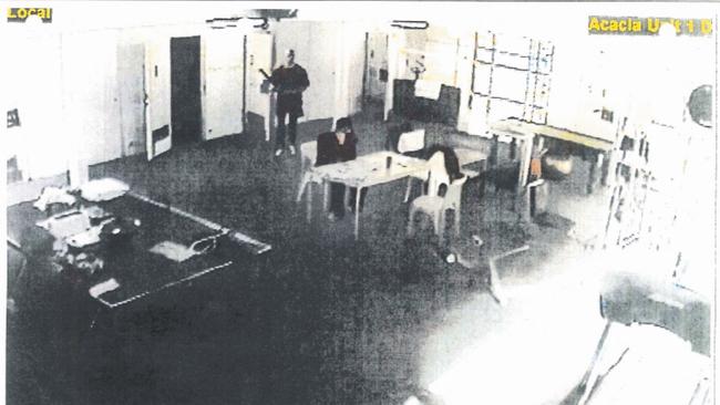 An artist enhanced version of court supplied CCTV still. Matthew Johnson stands behind Carl Williams in Barwon Prison before Johnson killed him. Picture: Supplied