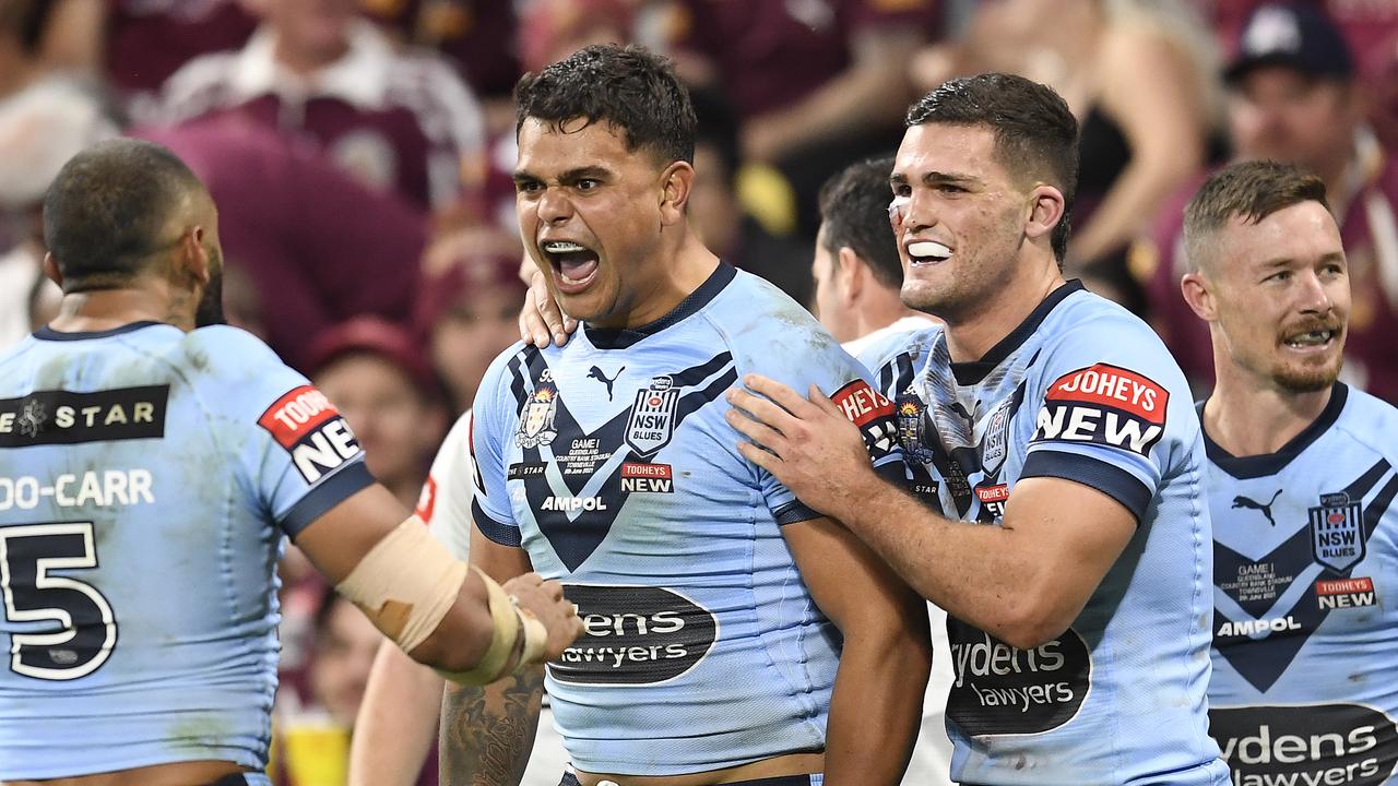 Latrell Mitchell celebrates with teammates after scoring a try