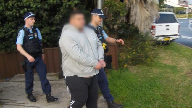 Saia Solofonti as he was marched from a property in Georges Hall during a dawn raid on Thursday.