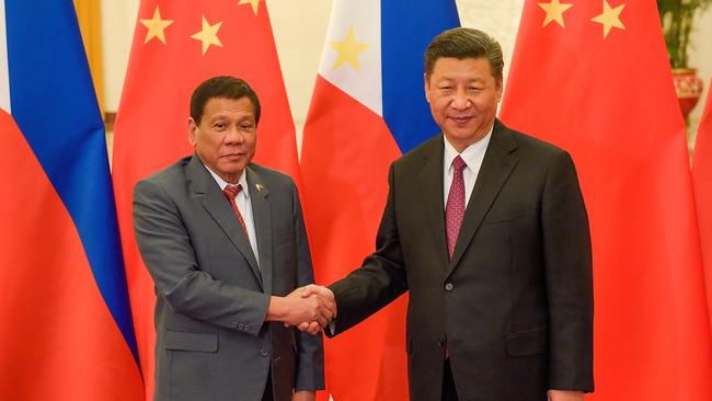 Chinese President Xi Jinping (R) shakes hands with Philippines President Rodrigo Duterte.