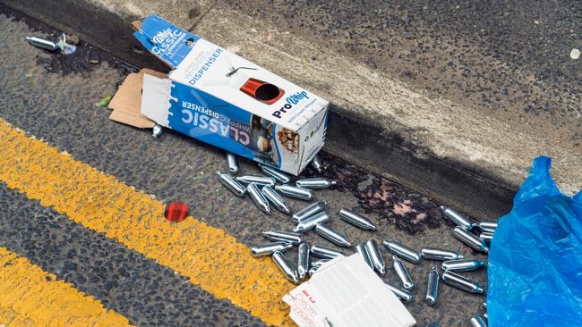 Discarded small nitrous oxide canisters and dispenser packaging from the use of the 'legal high' also known as NOS.