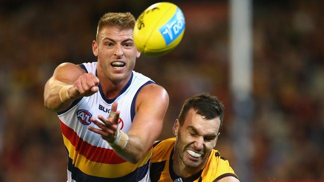 Daniel Talia of the Crows handballs while being tackled by Hawthorn’s Jonathon Ceglar. Picture: Quinn Rooney (etty Images)