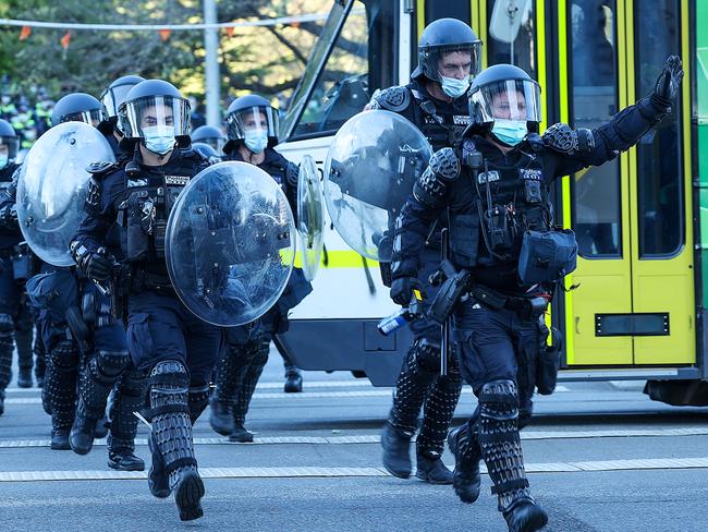 Melbourne riot police chase after protesters who fled from the Shrine of Remembrance. Picture: NCA NewsWire / Ian Currie