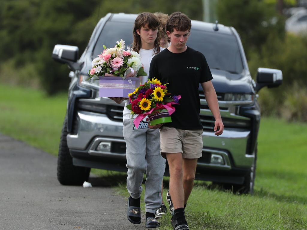 Young mourners lay flowers at the scene. Picture: Max Mason-Hubers