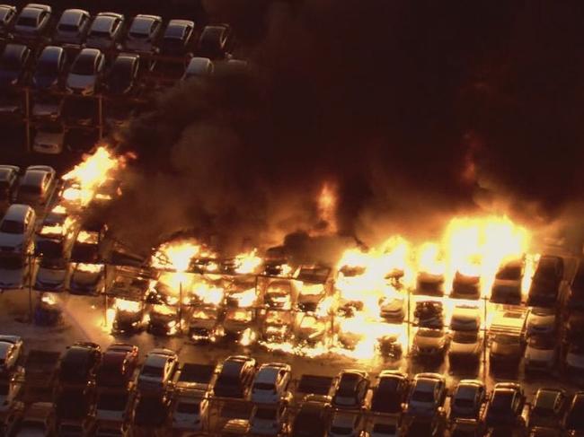 A massive blaze has erupted in a car yard in Perth, resulting in the destruction of dozens of cars.