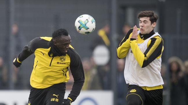 Jamaica's former sprinter Usain Bolt, left, heads the ball towards Dortmund's Tim Sechelmann