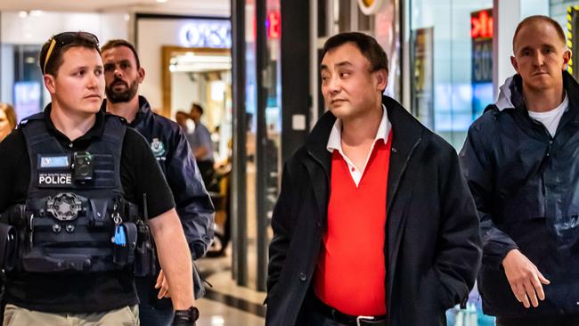 Jin Long Wang was escorted from the centre by police. (AAP IMAGE/MONIQUE HARMER)