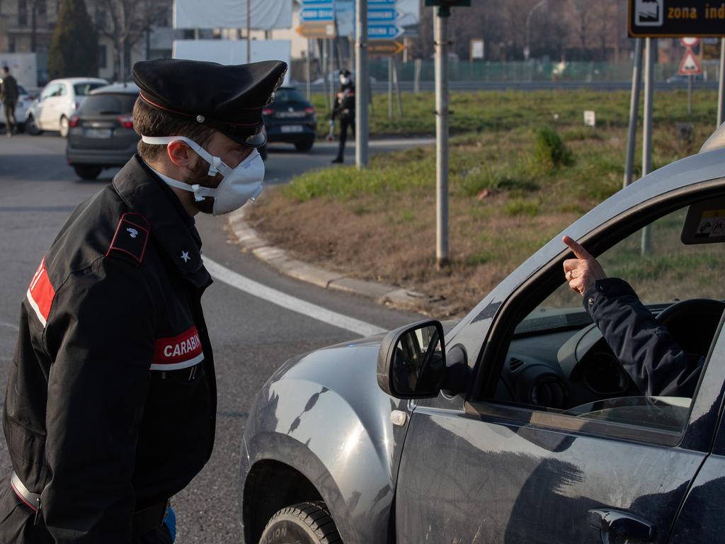 An Italian Carabinieri officer talks to a driver at a roadblock in Guardamiglio, southwest Milan, Italy. Picture: Emanuele Cremaschi/Getty Images